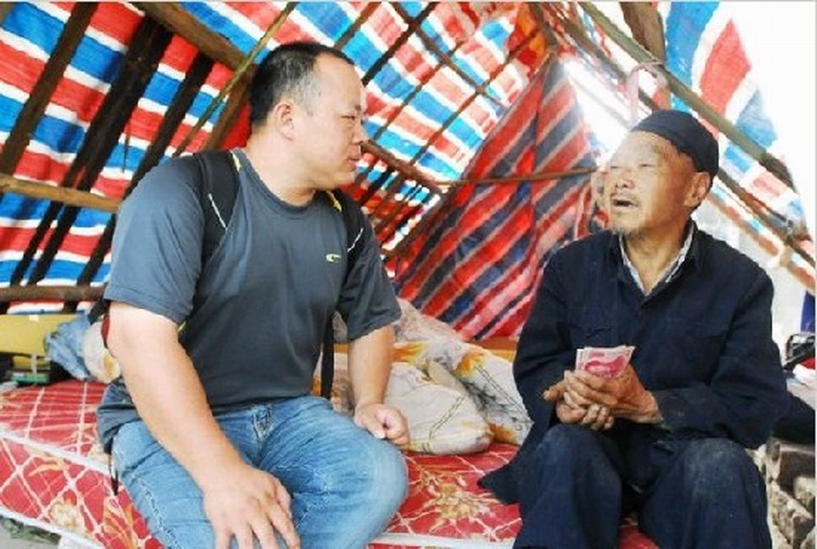 賴金土（左）在地震災區給災民分發錢物