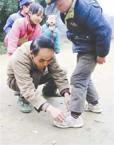 遊戲時學生的鞋帶散了周宏軍俯身為他繫鞋帶