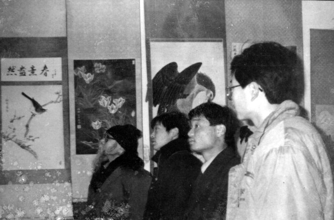 張一圃先生在學生陪同下參觀畫展。