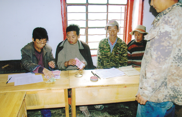 王建（左一）生前和隊友們為民眾修建水渠發放補助金