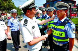 武漢市交管局政委王斌在為交警擦汗