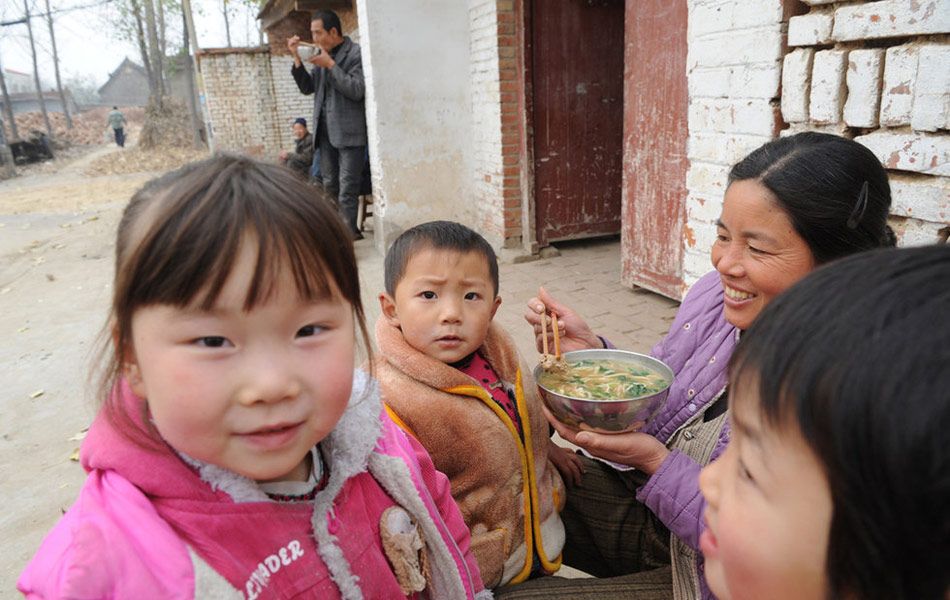 一位母親在文樓村的村頭給孩子餵飯