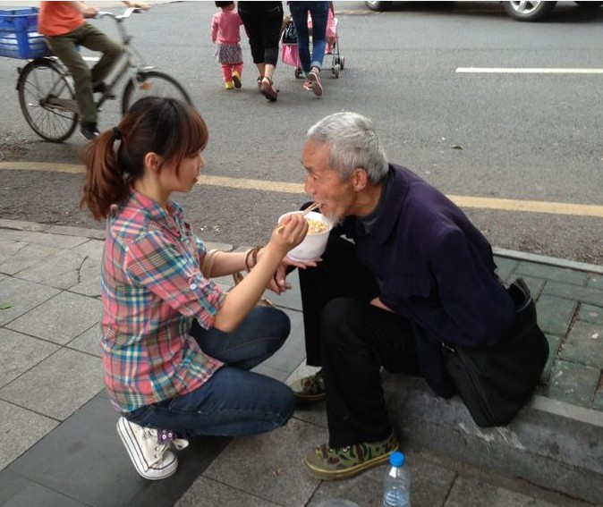 90後女孩當街給乞丐餵飯圖