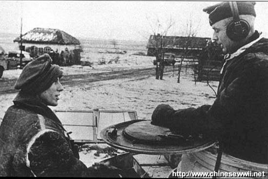 舒爾茨少將〔右〕在指揮坦克上與部下交談