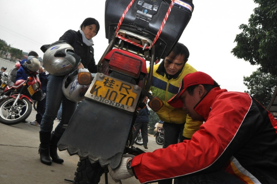 志願者為返鄉的務工人員檢修機車