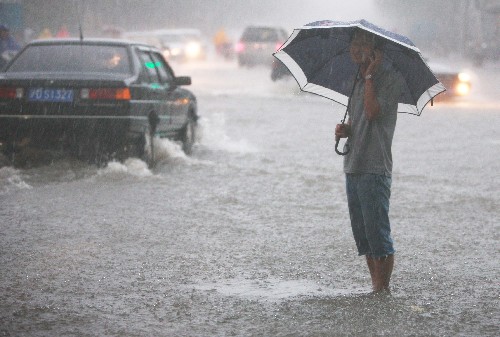 一名行人在雨中打電話