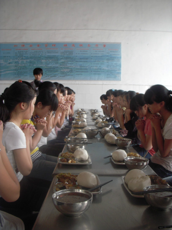 食堂里同學正在祈禱。