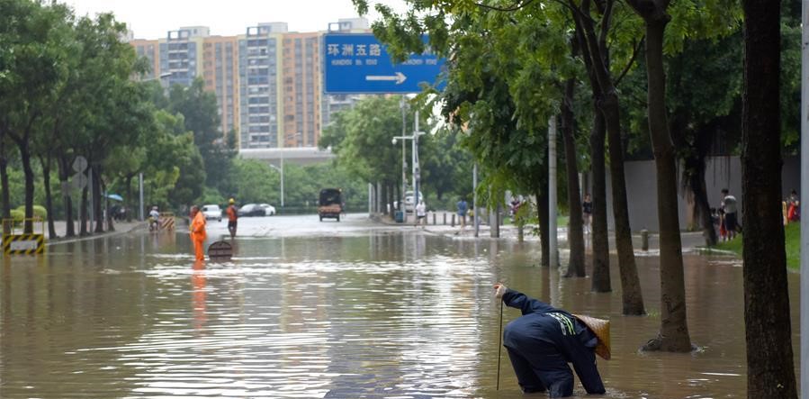 工作人員在廣州市白雲區一處積水路段開展搶修作業